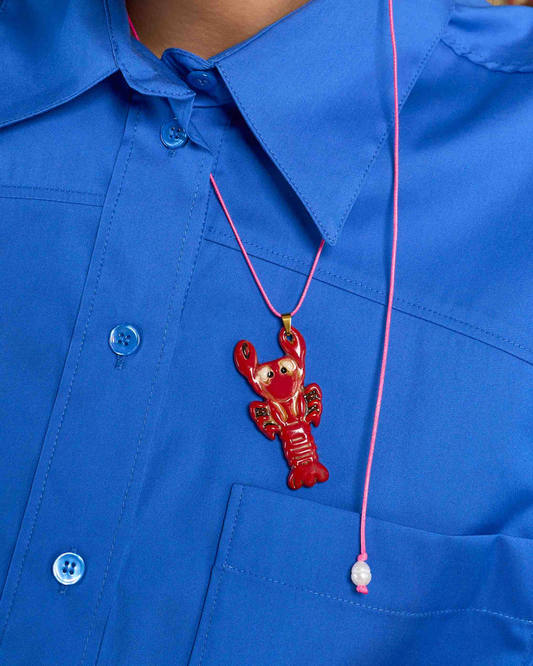 ceramic lobster charm on pink cord necklace on model close up