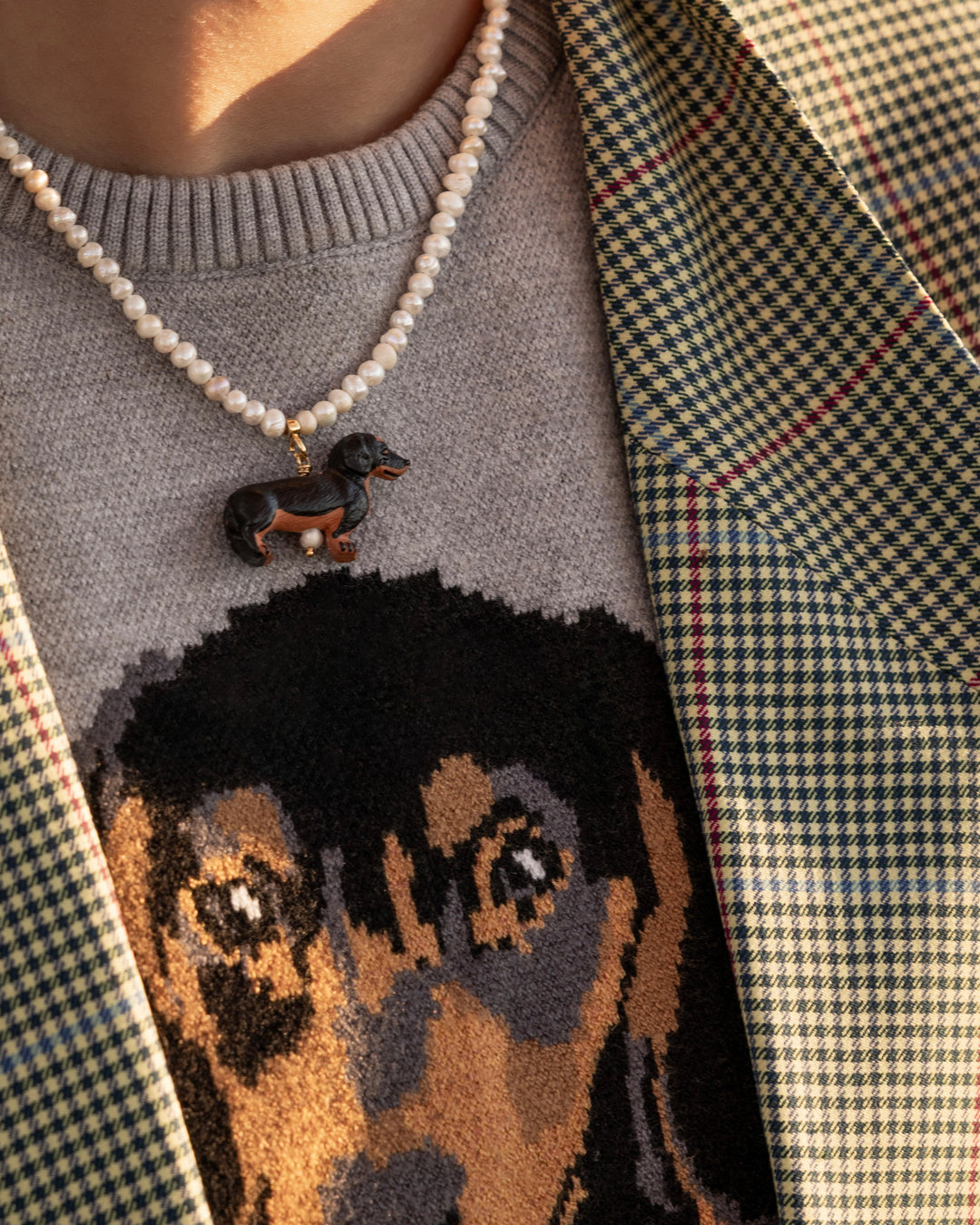 close up pearls and sausage dog charm necklace on model