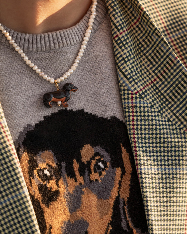 close up pearls and sausage dog charm necklace on model