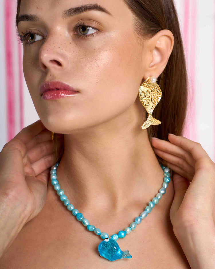 golden metal fish earrings with removable pearl on model