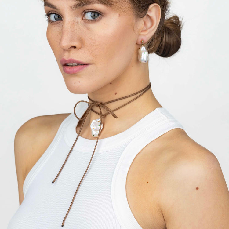 model wearing a cord necklace with baroque pearl