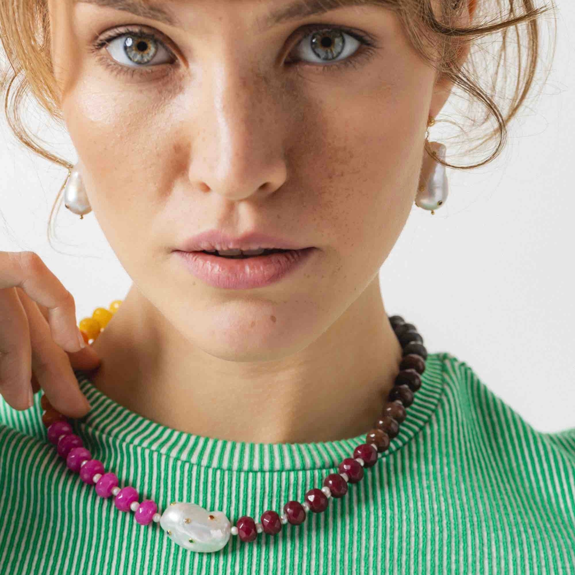 model wearing a jade stones necklace with baroque pearl in the centre