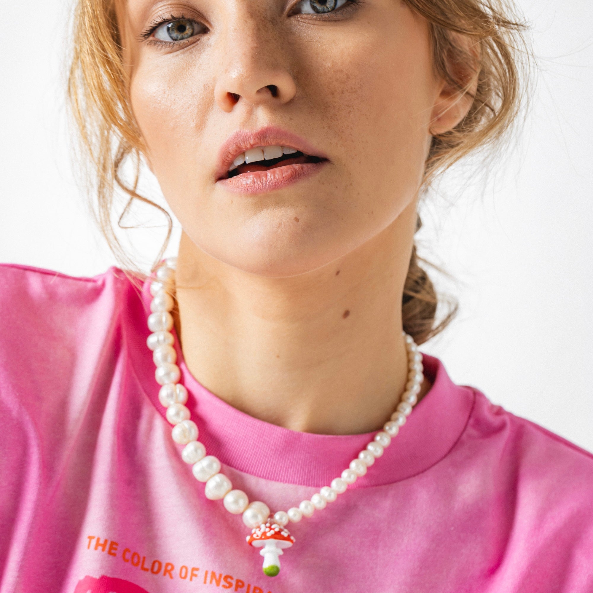 model wearing a mushroom pendant and pearls necklace