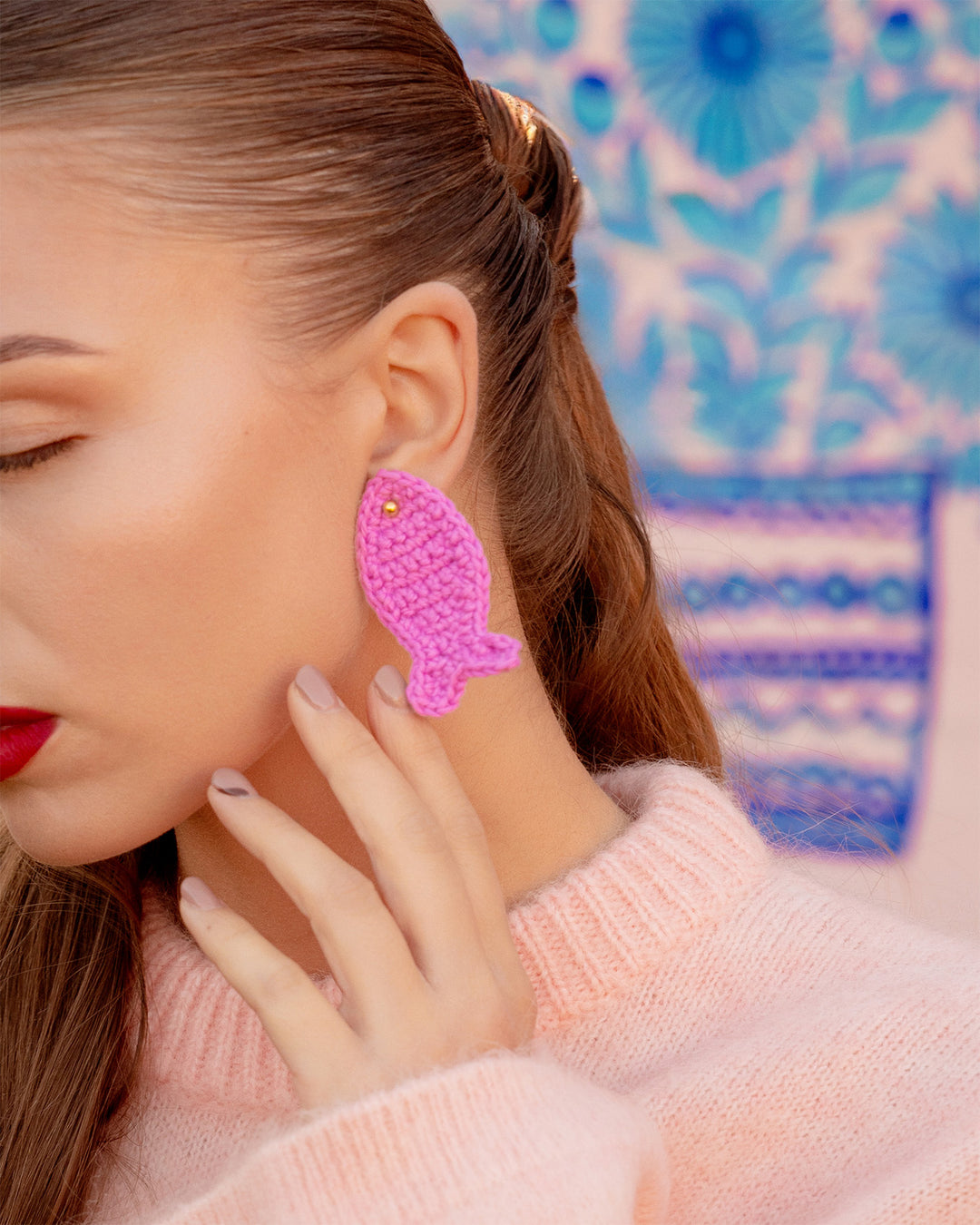 pink crochet fish earrings with gold stud on model