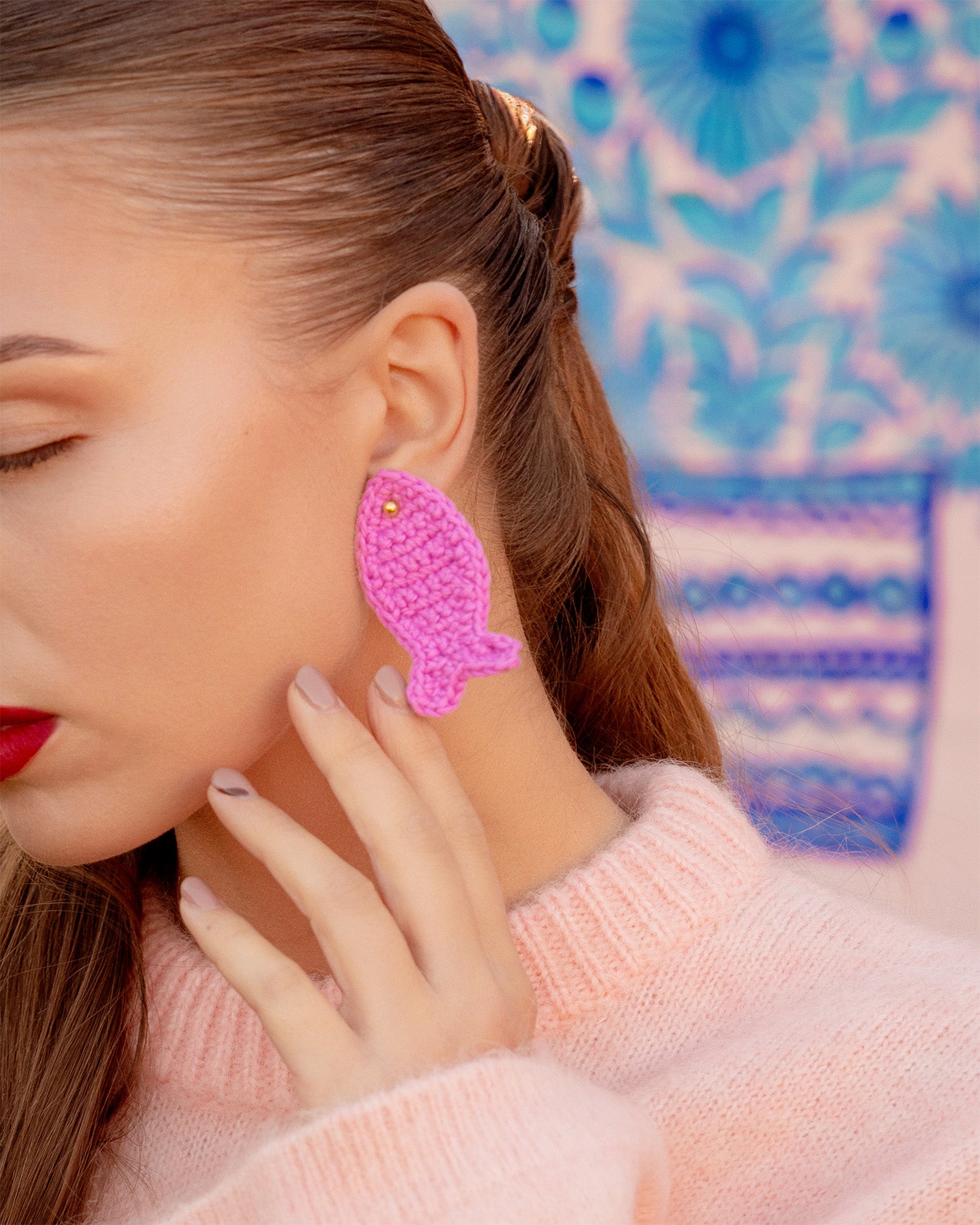 pink crochet fish earrings with gold stud on model